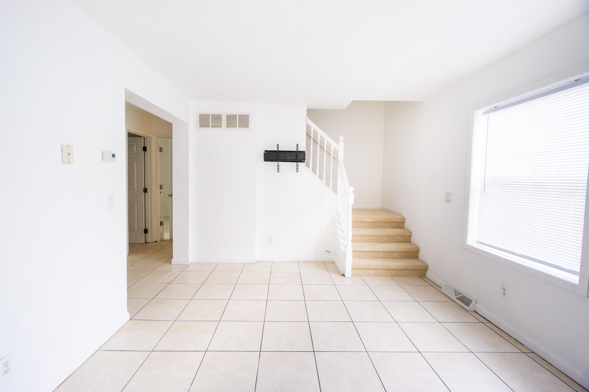 First floor living room facing the stairs with windows to the right.